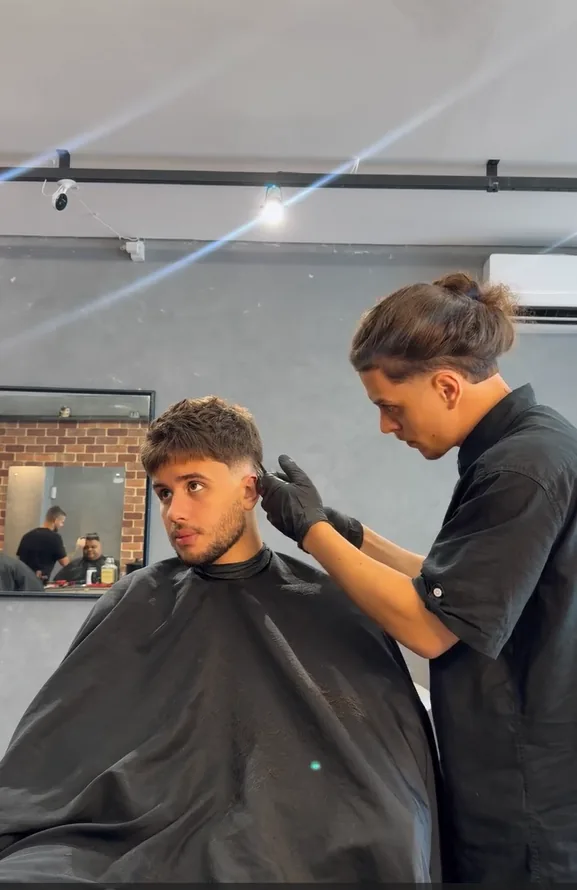 Barbeiro da 4º Distrito realizando corte masculino